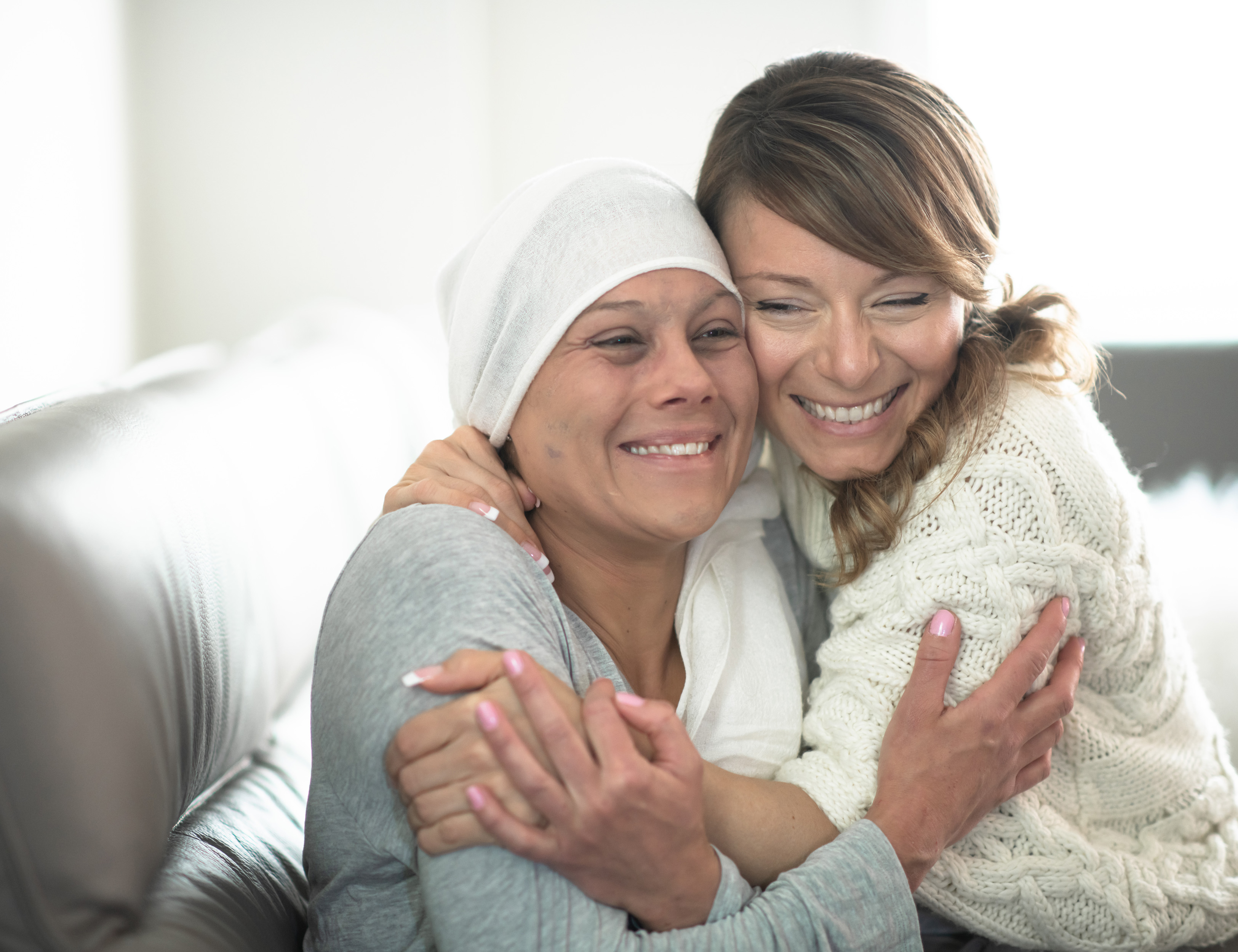 Oncology patient and friend hugging and smiling