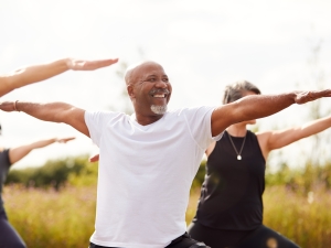 Group of middle aged people practicing yoga in the evening outdoors